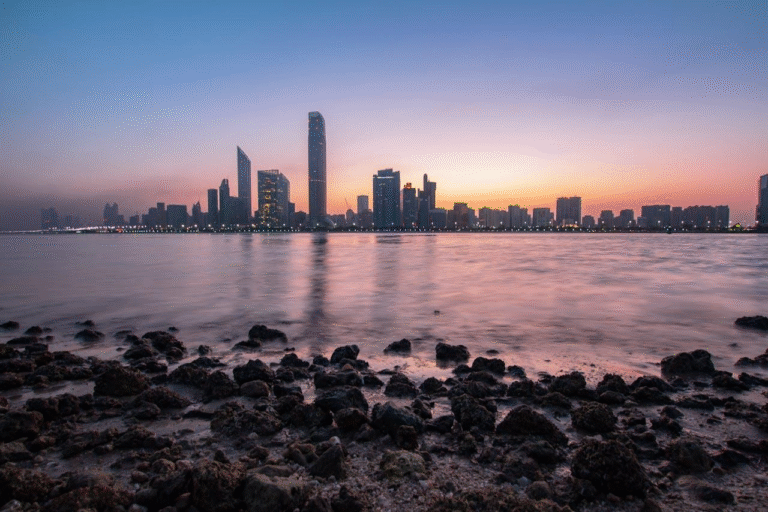 Abu Dhabi skyline at sunset with city buildings along the Corniche